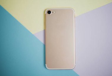 Renkli arkaplanda fotokopi alanı olan akıllı telefon. Modern ve minimal biçim rengi