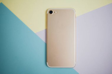 Renkli arkaplanda fotokopi alanı olan akıllı telefon. Modern ve minimal biçim rengi