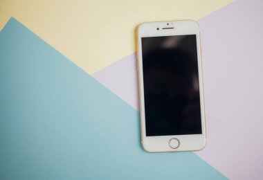 Renkli arkaplanda fotokopi alanı olan akıllı telefon. Modern ve minimal biçim rengi