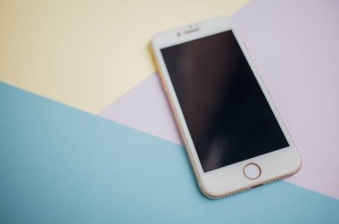 Renkli arkaplanda fotokopi alanı olan akıllı telefon. Modern ve minimal biçim rengi