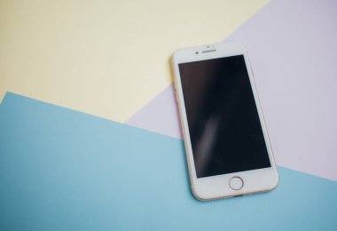 Renkli arkaplanda fotokopi alanı olan akıllı telefon. Modern ve minimal biçim rengi