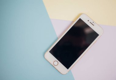 Renkli arkaplanda fotokopi alanı olan akıllı telefon. Modern ve minimal biçim rengi