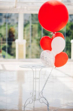 Renkli balonlar tatil masasına yakın, parlak kutlama dekorasyonu