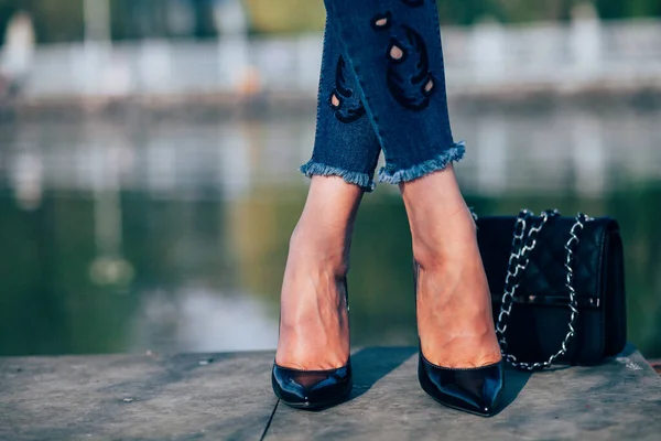 modelo usa calça jeans azul clara, bota de salto alto preta