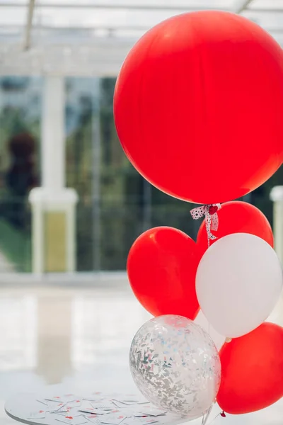 Renkli balonlar tatil masasına yakın, parlak kutlama dekorasyonu