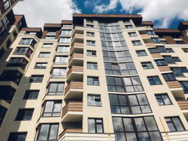 Güneşli bir günde mavi gökyüzü olan modern apartmanlar. Modern bir apartmanın cephesi
