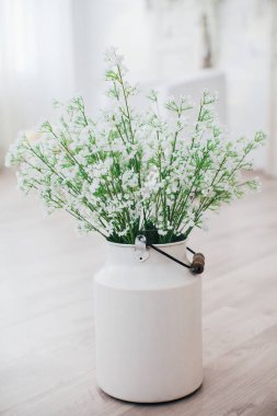 Metal bir vazoda beyaz çiçekler, saplı, antika, stüdyo dekorlu. 