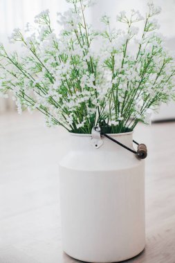 Metal bir vazoda beyaz çiçekler, saplı, antika, stüdyo dekorlu. 