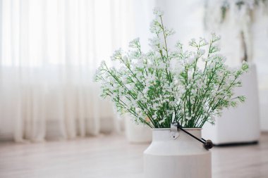 Metal bir vazoda beyaz çiçekler, saplı, antika, stüdyo dekorlu. 