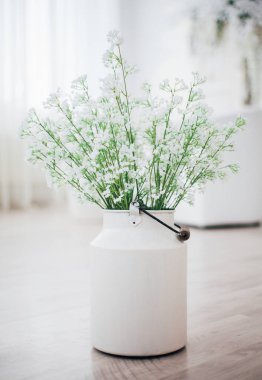 Metal bir vazoda beyaz çiçekler, saplı, antika, stüdyo dekorlu. 