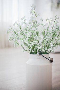 Metal bir vazoda beyaz çiçekler, saplı, antika, stüdyo dekorlu. 