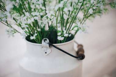 Metal bir vazoda beyaz çiçekler, saplı, antika, stüdyo dekorlu. 