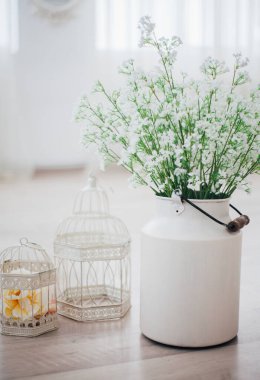 Metal bir vazoda beyaz çiçekler, saplı, antika, stüdyo dekorlu. 