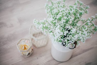 Metal bir vazoda beyaz çiçekler, saplı, antika, stüdyo dekorlu. 