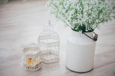 Metal bir vazoda beyaz çiçekler, saplı, antika, stüdyo dekorlu. 