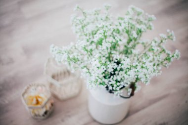 Metal bir vazoda beyaz çiçekler, saplı, antika, stüdyo dekorlu. 