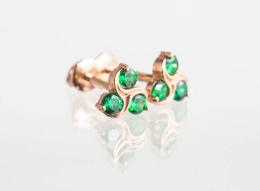 Beyaz arka planda izole edilmiş bir çift altın küpe.