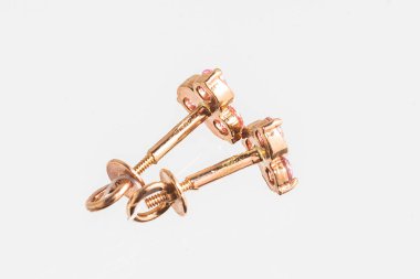 Beyaz arka planda izole edilmiş bir çift altın küpe.