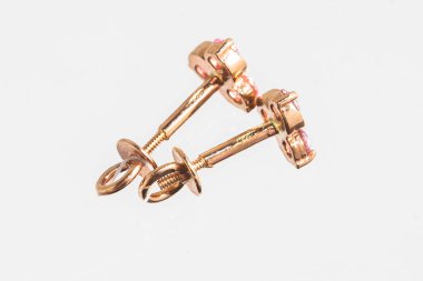 Beyaz arka planda izole edilmiş bir çift altın küpe.