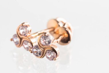 Beyaz arka planda izole edilmiş bir çift altın küpe.