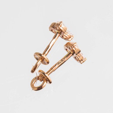 Beyaz arka planda izole edilmiş bir çift altın küpe.