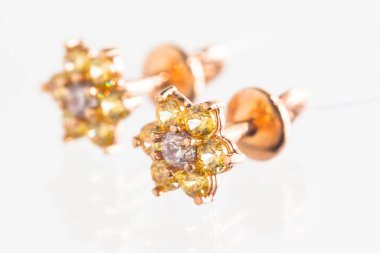 Beyaz arka planda izole edilmiş bir çift altın küpe.