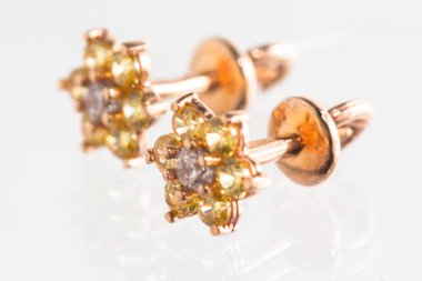 Beyaz arka planda izole edilmiş bir çift altın küpe.