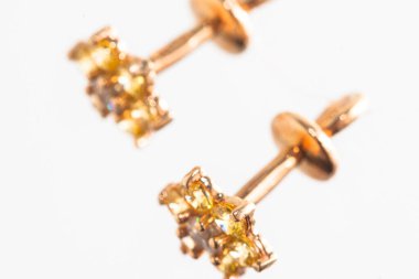 Beyaz arka planda izole edilmiş bir çift altın küpe.