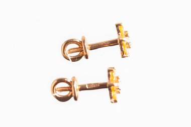 Beyaz arka planda izole edilmiş bir çift altın küpe.