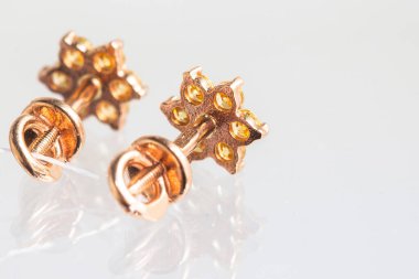 Beyaz arka planda izole edilmiş bir çift altın küpe.