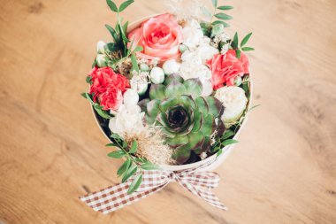 Şapka kutusunda güzel bir çiçek aranjmanı, ahşap arka plan. 