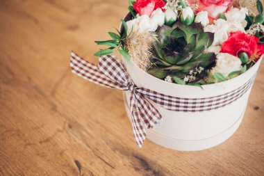 Şapka kutusunda güzel bir çiçek aranjmanı, ahşap arka plan. 