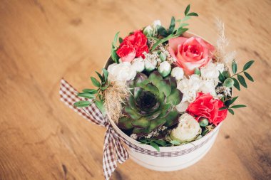 Şapka kutusunda güzel bir çiçek aranjmanı, ahşap arka plan. 