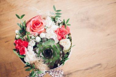 Şapka kutusunda güzel bir çiçek aranjmanı, ahşap arka plan. 