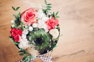 Şapka kutusunda güzel bir çiçek aranjmanı, ahşap arka plan. 