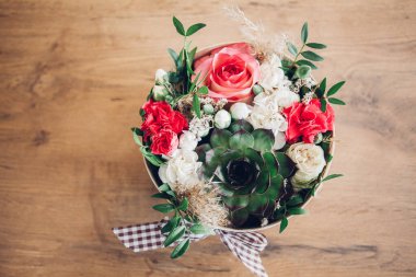 Şapka kutusunda güzel bir çiçek aranjmanı, ahşap arka plan. 