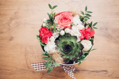 Şapka kutusunda güzel bir çiçek aranjmanı, ahşap arka plan. 