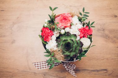 Şapka kutusunda güzel bir çiçek aranjmanı, ahşap arka plan. 