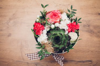 Şapka kutusunda güzel bir çiçek aranjmanı, ahşap arka plan. 