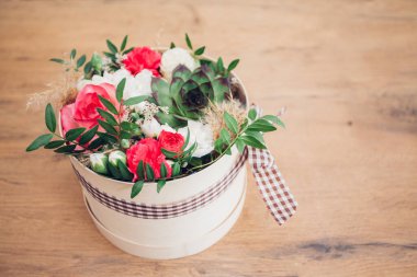 Şapka kutusunda güzel bir çiçek aranjmanı, ahşap arka plan. 