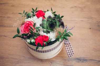 Şapka kutusunda güzel bir çiçek aranjmanı, ahşap arka plan. 