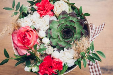 Şapka kutusunda güzel bir çiçek aranjmanı, ahşap arka plan. 