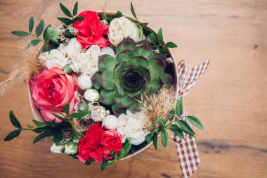 Şapka kutusunda güzel bir çiçek aranjmanı, ahşap arka plan. 