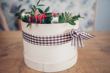 Şapka kutusunda güzel bir çiçek aranjmanı, ahşap arka plan. 