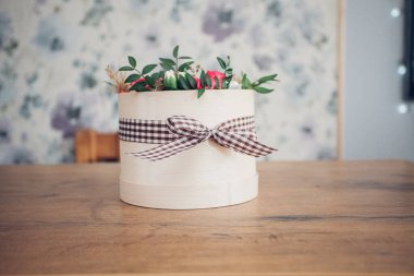 Şapka kutusunda güzel bir çiçek aranjmanı, ahşap arka plan. 