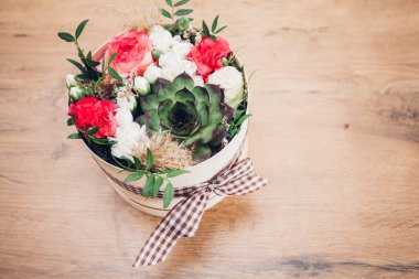 Şapka kutusunda güzel bir çiçek aranjmanı, ahşap arka plan. 