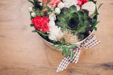 Şapka kutusunda güzel bir çiçek aranjmanı, ahşap arka plan. 