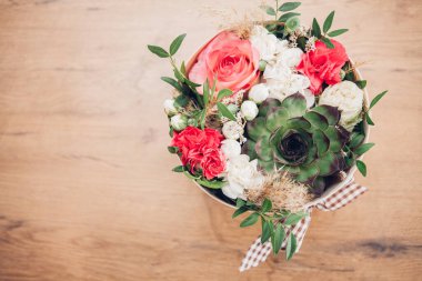 Şapka kutusunda güzel bir çiçek aranjmanı, ahşap arka plan. 