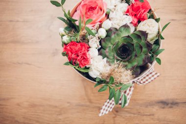 Şapka kutusunda güzel bir çiçek aranjmanı, ahşap arka plan. 