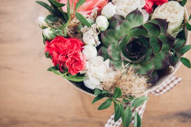 Şapka kutusunda güzel bir çiçek aranjmanı, ahşap arka plan. 